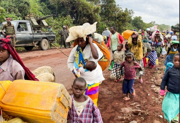Congolese civilians carry their belongings as they flee near the Congolese border.
Photo Courtesy of the Reuters.