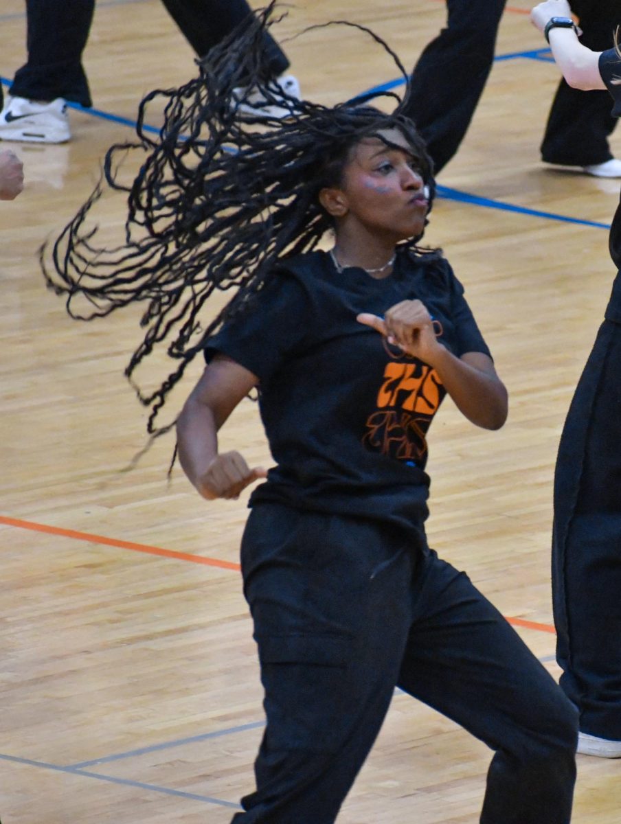 At an assembly, teachers and students provide examples of good and bad dancing for an upcoming dance.