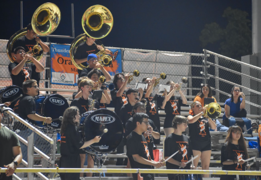 Orange Crush marching band performing at a home varsity football game.
