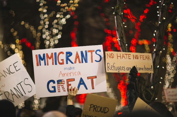 Protestors hold up signs supporting the presence of immigrants in America. Photo by Nitish Meena on Unsplash. Taken in Seattle, WA. Published on January 29, 2017.